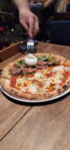 濃厚なブッラータとパルマハムのピザ、旨辛シーフードスパイシートマトの2種が楽しめるPizza 4P’sのハーフ&ハーフピザ。焼きたての香ばしさが魅力。